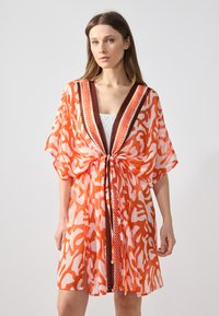Kimono in stampa arancione e bianco, realizzato in tessuto leggero, con scollo a V e rifiniture marroni, vita cinchata, maniche ampie e design fluido.