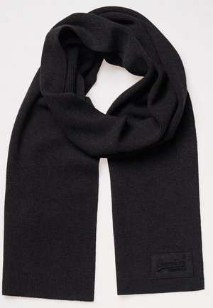 Schwarzer gestrickter Schal mit gerippter Textur und einem kleinen rechteckigen Stofflogo-Etikett an einem Ende, flach liegend mit einer lockeren Schlaufe oben.