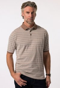 Hnědý pruhovaný polo tričko s hnědým límečkem, má krátké rukávy a náprsní kapsu. Materiál vypadá hladce a má volný střih.
