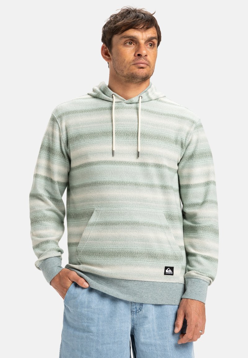 Sudadera de rayas verde claro con bolsillo tipo canguro, cordones, puños acanalados y un parche con el logo en el dobladillo inferior. Tela suave y texturizada.