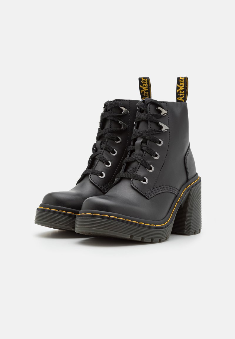 Schwarze Lederstiefeletten mit einem klobigen, strukturierten Absatz, Schnürung vorn, silbernen Ösen und gelben Nähakzenten. Verfügt über eine Ziehlasche.