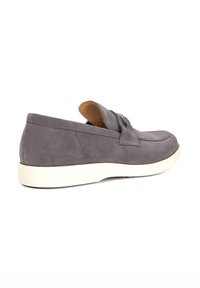 Gray suede slip-on shoe with a rounded toe, white rubber sole, and decorative strap with hardware detail on the upper.