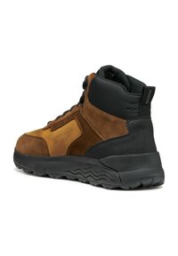Botas de senderismo de ante y goma en marrón y negro, de media altura, con parte superior texturizada, cierre de cordones y suela de goma con un patrón en forma de ola.