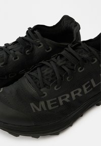 Scarpe sportive nere realizzate in mesh traspirante, con superfici testurizzate, lacci neri piatti e un logo "MERRELL" prominente sul lato.