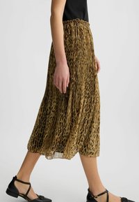 Gonna midi plissettata in tessuto leggero e trasparente con un motivo a stampa leopardata in tonalità di marrone caldo e nero. Vita elastica, design fluido.