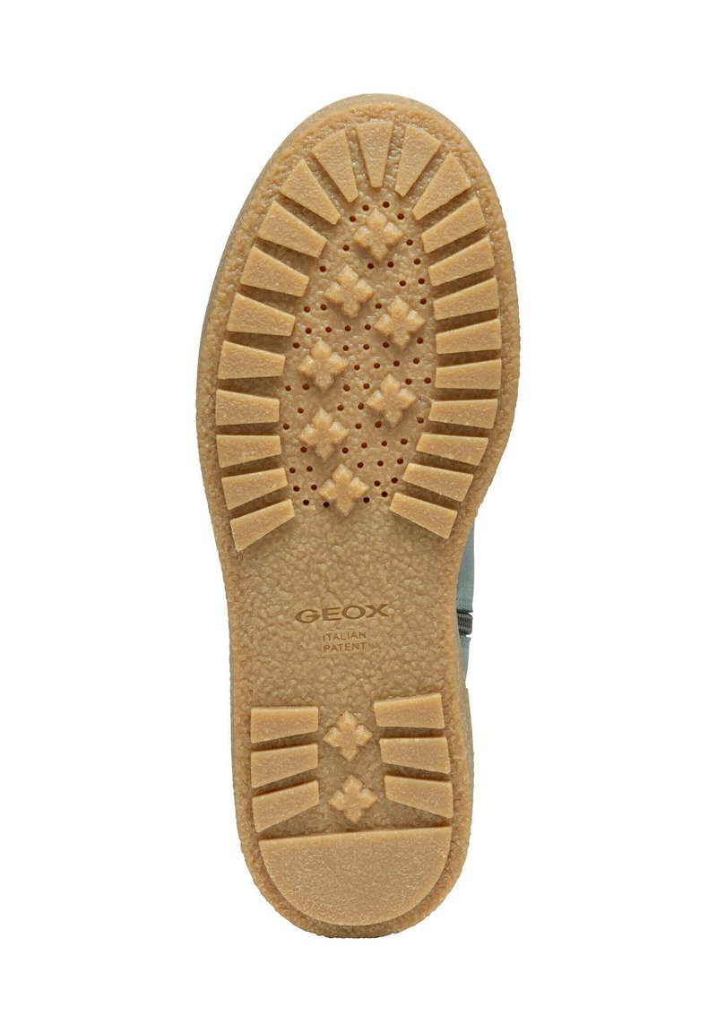 La semelle de chaussure GEOX en caoutchouc beige présente une surface texturée avec des rainures et un design perforé pour la respirabilité et l'adhérence.
