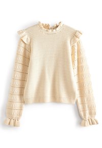 Pull beige en tricot avec poignets à volants, encolure à volants et manches bouffantes présentant un motif ajouré.