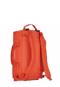 Mochila rectangular de color naranja brillante con correas de hombro acolchadas, asa superior, asas laterales y el logo blanco de "Haglöfs" en el lateral.