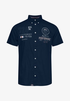 Marineblå kortermet skjorte med knapper, som har broderte detaljer, inkludert tall og tekst, samt en rund kant.