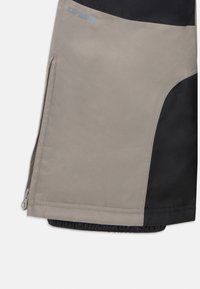 Vannavstøtende bukser i grå og svart med en jevn tekstur. Har en glidelåslomme og elastiske mansjetter for en sikker passform.