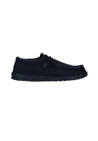Zapatos de tela negros tipo slip-on con un upper texturizado, diseño de punta ovalada y suela de goma con un ligero tacón. Incluyen cordones ajustables.
