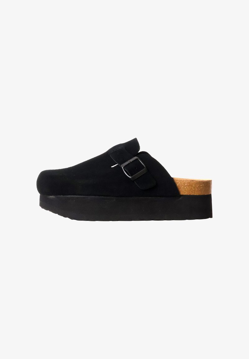 Sabot en daim noir avec sangle à boucle réglable, semelle intérieure en liège et semelle épaisse noire, présenté de profil sur fond blanc.