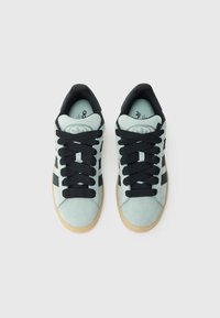 Αθλητικά παπούτσια σε ανοιχτό μέντα σουέτ με μαύρα κορδόνια, με μαύρες ρίγες στις πλευρές και σόλα από καουτσούκ χρώματος καραμέλας για καλύτερη πρόσφυση.