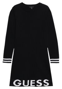 Musta neulemekko pitkilla hihoilla, pyöreällä pääntiellä ja valkoisilla raidoilla hihoissa. Sisältää "GUESS"-logon helman kohdalla kontrastoivalla valkoisella.