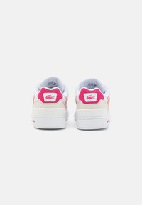 White and pink sneakers featuring a textured upper, padded collar, and a prominent brand logo on the heel. Smooth rubber sole.