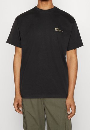 Schwarzes Baumwoll-T-Shirt mit klassischem Rundhalsausschnitt und kurzen Ärmeln. Mit einem goldenen, auf der linken Brust aufgedruckten Logo.