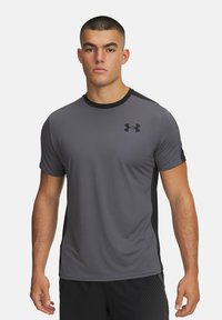 Camiseta deportiva gris con acentos negros, de manga corta, cuello redondo y logo en el pecho. Fabricada con material ligero y transpirable.