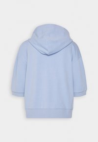 Světle modrá mikina s krátkým rukávem a žebrovanými manžetami a spodním lemem, zobrazená zezadu na jednobarevném bílém pozadí.