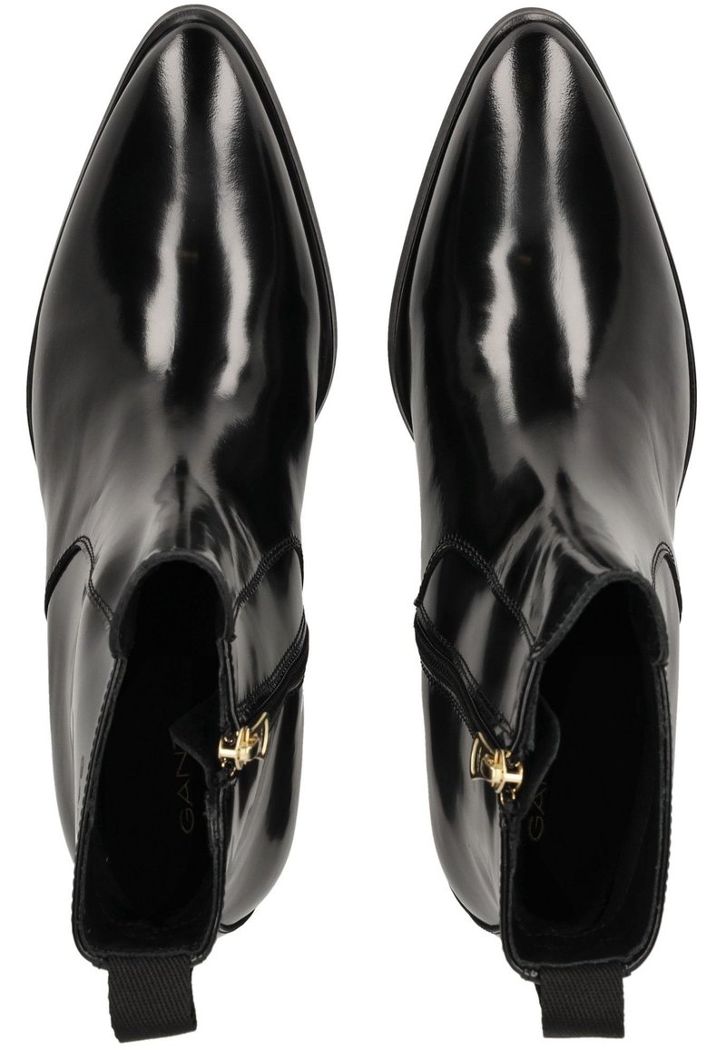 Schwarze Leder-Stiefeletten mit glänzender Oberfläche, spitz zulaufender Zehenpartie, seitlichen Reißverschlüssen und goldenen Hardware-Akzenten. Glatte Textur und elegantes Design.