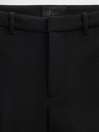 Pantalon noir sur mesure avec une texture lisse, présentant un devant plat, des passants pour ceinture et une étiquette GAP Studio à la taille.