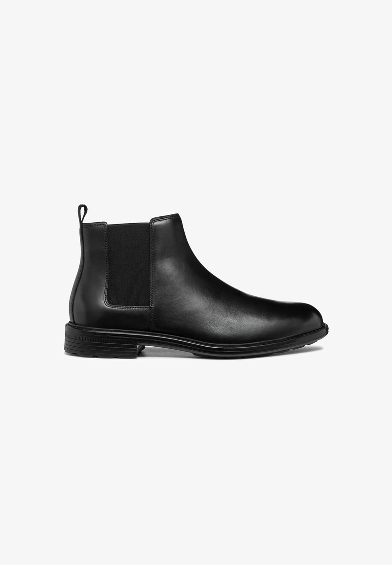 Stivale Chelsea in pelle nera con pannelli laterali elasticizzati, punta rotonda e linguetta sul retro. Presenta una suola in gomma testurizzata.