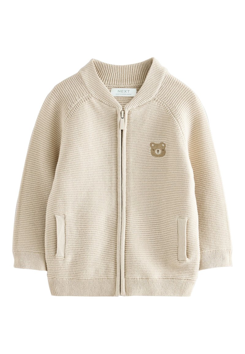 Beige zip-up cardigan in textured knit. Features a bear graphic on the chest, ribbed cuffs, and two side pockets. Suitable for layering.