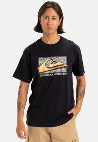 T-shirt in cotone nero con un grande logo grafico multicolore. Design a maniche corte e collo rotondo con vestibilità rilassata.
