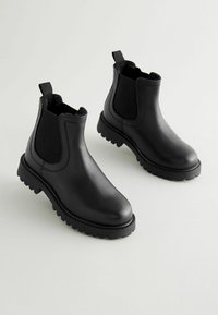 Svarta läder Chelsea-boots med en texturerad yta, elastiska sidopaneler och en kraftig gummisula med djupa mönster för bra grepp.