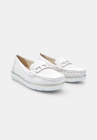 Scarpe bianche senza lacci con tomaia in tessuto testurizzato, dettagli in pelle a contrasto e una decorazione cucita. Suola in gomma per una migliore presa.