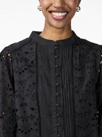 Black embroidered blouse with a high collar, buttoned front, textured fabric, and decorative cutouts. Features pleats and lace details.