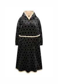 Coperta con cappuccio nera, decorata con un grande motivo circolare bianco, con un morbido interno beige, vita cinchata e orlo a ondine.
