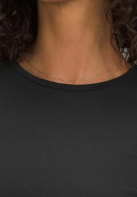 Czarna bluzka z okrągłym dekoltem wykonana z gładkiej tkaniny, zestawiona z delikatnym złotym naszyjnikiem. Zbliżenie podkreśla szczegóły dekoltu i biżuterii.