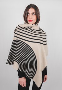Poncho a righe beige e nere, con motivi circolari e bordi sfrangiati. Realizzato in tessuto morbido, progettato per cadere elegantemente.