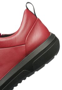 Rote Leder-Sneaker mit strukturiertem Finish, ausgestattet mit einer schwarzen Gummisohle und -ferse, einem Zugtab und einem eleganten, modernen Design.