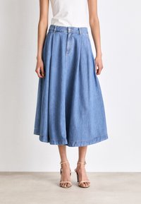 Jupe midi en denim bleu clair, avec un design plissé, taille haute et fermeture par bouton. Texture douce avec un ourlet au bas.
