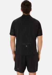 Sort vest med korte meshærmer, funktionel baglomme og minimalistisk design. Letvægtsstof med en glat tekstur.