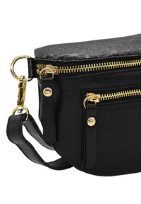 Sac en cuir noir avec des zips dorés, présentant une surface texturée, deux compartiments et une bandoulière réglable.
