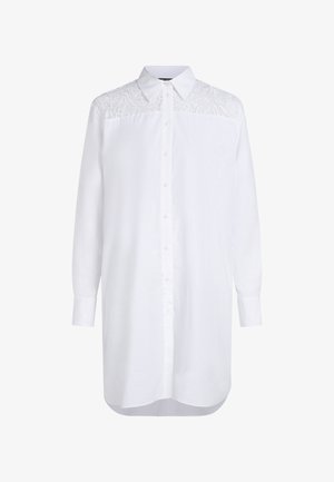 Bela dolga majica z dolgimi rokavi z gumbi spredaj, ki ima čipkast detajl na ramenih in ukrivljen rob. Material iz mešanice bombaža.