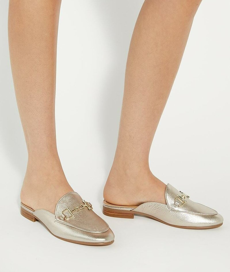 Metalen gouden loafers met een instapontwerp, voorzien van een gestructureerde afwerking, gouden hardwareaccent en een lage houten hak.