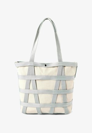 Sac fourre-tout en toile beige avec des sangles verticales et horizontales gris clair, deux anses d'épaule, et une fermeture unique à bouton-pression en haut.