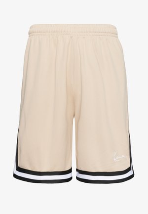 Bézs színű sportnadrág elasztikus derékrésszel, a szegélyén fekete-fehér csíkozott szegéllyel és kis fehér, írott logóval a jobb lábszáron.