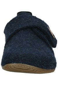 Marineblauwe pantoffel van fuzzy vilt, met een klittenbandsluiting en een getextureerde bruine rubberen zool met een golfpatroon. Gestructureerd, afgerond ontwerp.