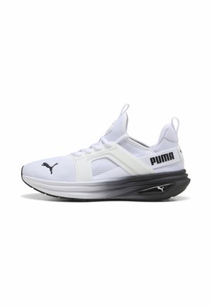 Witte Puma sneaker met zwarte zool en Puma-logo op teen en zijkant, met mesh bovenwerk en pull tabs op tong en hiel.