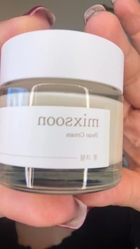 Glasbeholder med creme med hvidt låg, klar beholder der afslører lys creme indeni, mærket "mixsoon bean cream" med elegant, minimalistisk skrifttype.