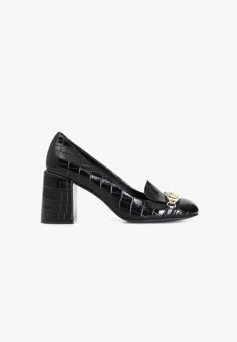 Zapatos de tacón bloque de charol negro con textura de cocodrilo, punta afilada y un acento de hardware en tono dorado en la parte delantera.