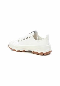 Zapatilla de lona blanca con superficie texturizada, suela de goma, ojales metálicos y suela exterior de color marrón claro. Diseño de corte bajo con cordones.
