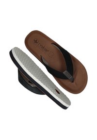 Bruine en zwarte slippers met een gestructureerde voetbed en een witte rubberen zool, met een grijze accent op de band en "Rieker Antistress" branding.