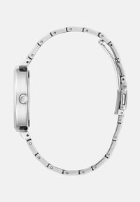 Srebrna kovinska zapestnica z gladko, okroglo ohišje in povezanimi pasovi. Ima preprosto krono in sijočo obdelavo, ki prikazuje eleganten, sodoben design.