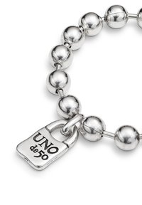 Bracelet en perles d'argent composé de perles métalliques arrondies et d'un pendentif en forme de cadenas gravé de "UNO de 50." Texture lisse et finition polie.