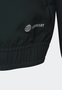 Chaqueta deportiva negra con una tela texturizada, dobladillo elástico y logo "AEROREADY" en blanco, situado en la parte inferior izquierda.